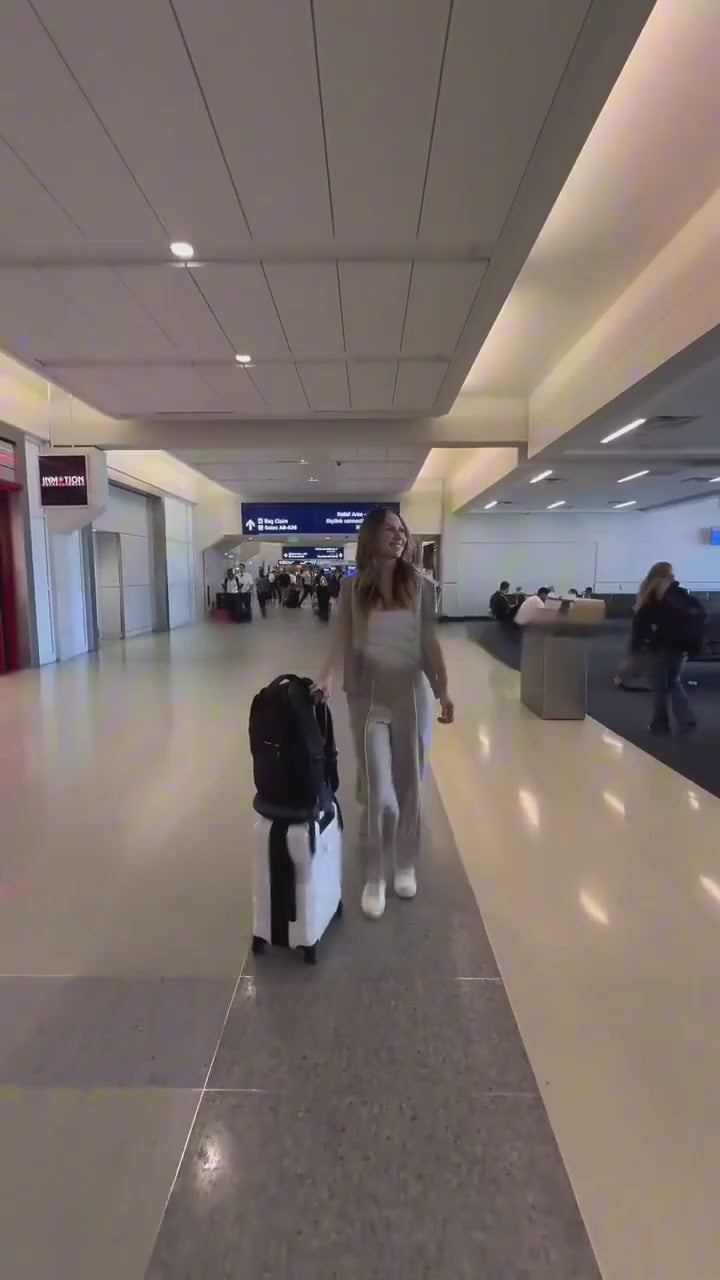 Une voyageuse se déplace avec ses bagages dans un aéroport